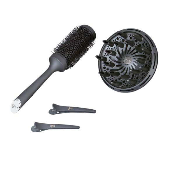 Secador de viaje air kit ghd el color predominante en la imagen es negro. Todos los objetos —el secador de pelo, el cepillo redondo, el difusor y las pinzas— son de color negro mate con algunos detalles metálicos en plateado, como el extremo del cepillo y pequeños acentos en el secador H2o Akua