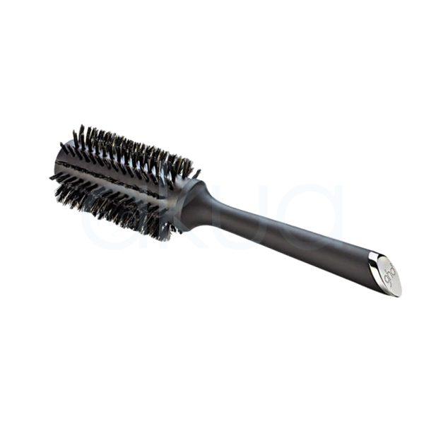 Cepillo ghd Bristle 35mm de color negro mate, con cerdas naturales de tono oscuro y un mango largo y ergonómico. En el extremo del mango se observa un detalle metálico plateado con el logotipo de ghd grabado. El cepillo está acompañado de su caja, también de color negro, con el nombre y detalles del producto impresos en letras doradas y blancas H2o Akua