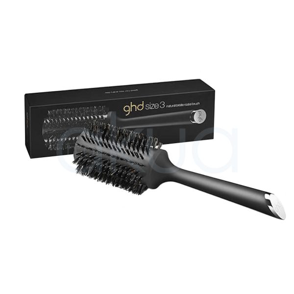 Cepillo ghd Bristle 44mm de color negro mate, con cerdas naturales de tono oscuro y un mango largo y ergonómico. En el extremo del mango se observa un detalle metálico plateado con el logotipo de ghd grabado. El cepillo está acompañado de su caja, también de color negro, con el nombre y detalles del producto impresos en letras doradas y blancas H2o Akua