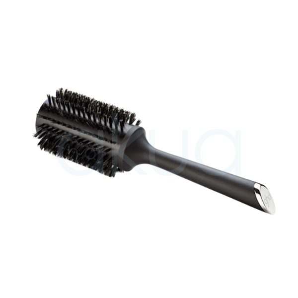 Cepillo ghd Bristle 44mm de color negro mate, con cerdas naturales de tono oscuro y un mango largo y ergonómico. En el extremo del mango se observa un detalle metálico plateado con el logotipo de ghd grabado. El cepillo está acompañado de su caja, también de color negro, con el nombre y detalles del producto impresos en letras doradas y blancas H2o Akua