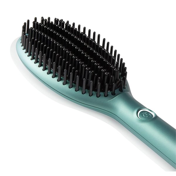 Cepillo ghd Glide Dreamland collection compuesto por una caja rectangular de color verde agua con detalles de estrellas doradas y texto en blanco, un cepillo alisador eléctrico del mismo tono verde agua con detalles metálicos en rosa dorado y cerdas negras, y un estuche cilíndrico de textura aterciopelada en color rosa empolvado con botones decorativos H2o Akua