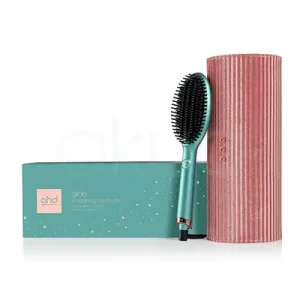 Cepillo ghd Glide Dreamland collection compuesto por una caja rectangular de color verde agua con detalles de estrellas doradas y texto en blanco, un cepillo alisador eléctrico del mismo tono verde agua con detalles metálicos en rosa dorado y cerdas negras, y un estuche cilíndrico de textura aterciopelada en color rosa empolvado con botones decorativos H2o Akua