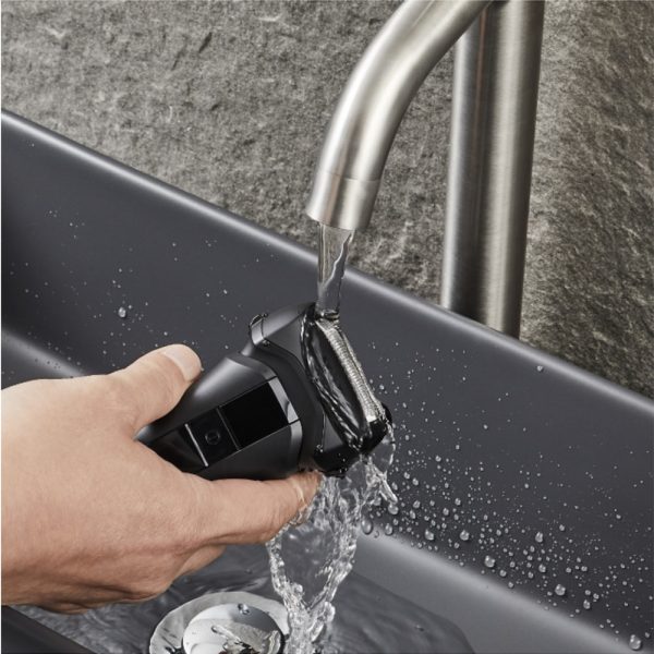 Afeitadora Panasonic ER-SP20 el color predominante es negro mate, con algunos detalles en negro brillante en la parte central del dispositivo. También se observan pequeños indicadores luminosos en blanco y un icono en rojo H2o Akua