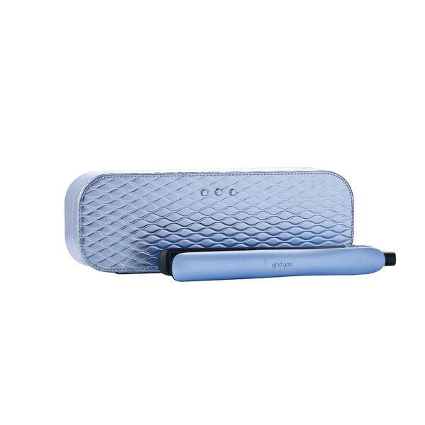 Plancha ghd Gold Blue Ice Collection de color azul claro en la parte exterior de su cuerpo, con un acabado mate. El interior, incluyendo las placas alisadoras y la base, es de color negro. Además, presenta detalles en gris en los botones y en la zona cercana al cable. El logotipo de la marca está impreso en color gris claro sobre el cuerpo azul H2o Akua