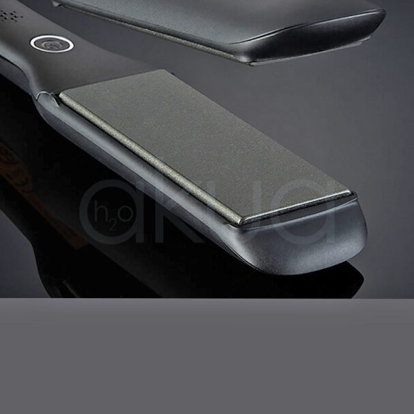 Plancha ghd Max core El color principal es negro mate cubriendo la mayor parte de su estructura. Negro brillante: Se observa en las placas alisadoras, que tienen un acabado más lustroso en contraste con el cuerpo mate, Blanco: Un pequeño detalle en forma de botón o aro decorativo cerca de la base del mango es de color blanco, Gris oscuro: En la zona cercana al cable, el acabado es de un tono gris oscuro o negro con textura H2o Akua