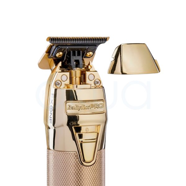 Maquina FXONE Gold Trimmer Babyliss Pro El color predominante es dorado metálico, presente tanto en el cuerpo principal de la máquina de corte como en la base del cargador y el mango del dispositivo. El recortador y la base tienen una textura grabada en dorado, lo que aporta un acabado elegante y lujoso. El cartucho de batería muestra detalles en azul translúcido con inscripciones en negro, añadiendo un contraste moderno al conjunto. Hay pequeños detalles en negro en la parte superior de la cuchilla y en la base del cargador, así como inscripciones en negro y azul en la batería H2o Akua