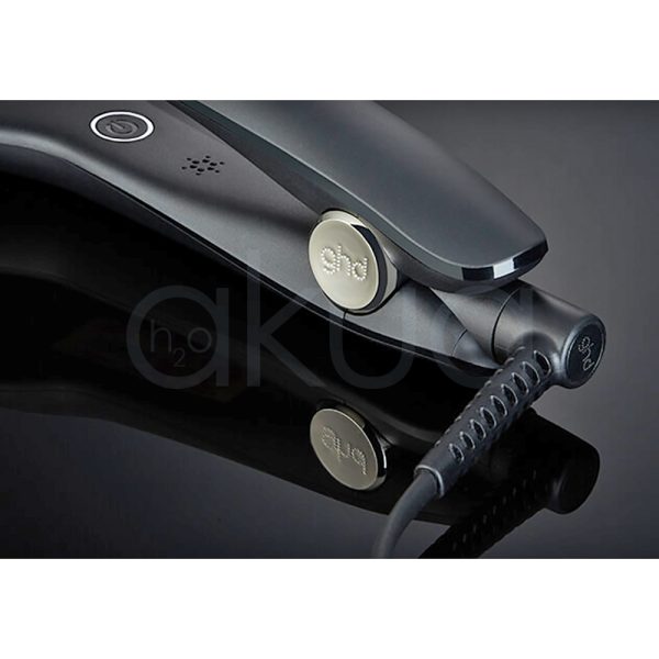Plancha ghd Max core El color principal es negro mate cubriendo la mayor parte de su estructura. Negro brillante: Se observa en las placas alisadoras, que tienen un acabado más lustroso en contraste con el cuerpo mate, Blanco: Un pequeño detalle en forma de botón o aro decorativo cerca de la base del mango es de color blanco, Gris oscuro: En la zona cercana al cable, el acabado es de un tono gris oscuro o negro con textura H2o Akua