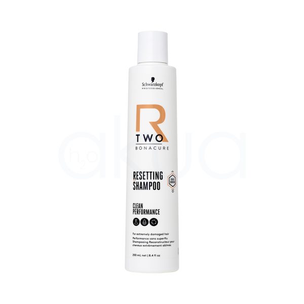 Champu Bonacure R-TWO Restaurador 250ml El color predominante del envase es blanco. Los textos y elementos gráficos incluyen detalles en negro (para la información), un logotipo en negro y un elemento decorativo llamativo en naranja (letra "R" y algunos detalles geométricos). La tapa del envase también es de color blanco translúcido y mate. H2o Akua