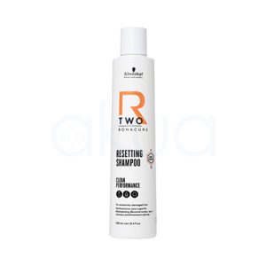 Champu Bonacure R-TWO Restaurador 250ml El color predominante del envase es blanco. Los textos y elementos gráficos incluyen detalles en negro (para la información), un logotipo en negro y un elemento decorativo llamativo en naranja (letra "R" y algunos detalles geométricos). La tapa del envase también es de color blanco translúcido y mate. H2o Akua