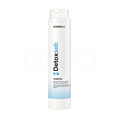 Champu regulador Detox Seb Montibello 300ml. Envase cilíndrico, alargado y vertical, con tapa tipo flip top en la parte superior. El color predominante es blanco, con detalles de texto en negro y azul claro, además de una franja azul en la parte baja del envase. H2o Akua
