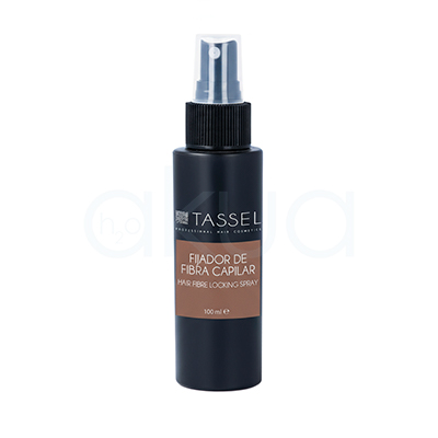 Fijador fibra capilar Tassel 100ml. De forma cilíndrica con un dosificador en spray en la parte superior. El cuerpo es de color negro mate, mientras que la etiqueta central es marrón clara, mostrando la información del producto en letras blancas. El pulverizador es de color negro con una boquilla traslúcida. H2o Akua