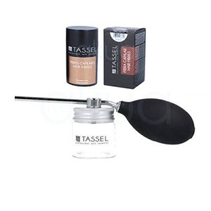 Aplicador fibras capilares Tassel. Frasco transparente con tapa metálica y una pera negra de goma en un extremo, conectados a una cánula larga y delgada. El frasco lleva el logo “TASSEL PROFESSIONAL HAIR COSMETICS” y está diseñado para almacenar las fibras capilares y facilitar su dosificación mediante presión de aire. H2o Akua