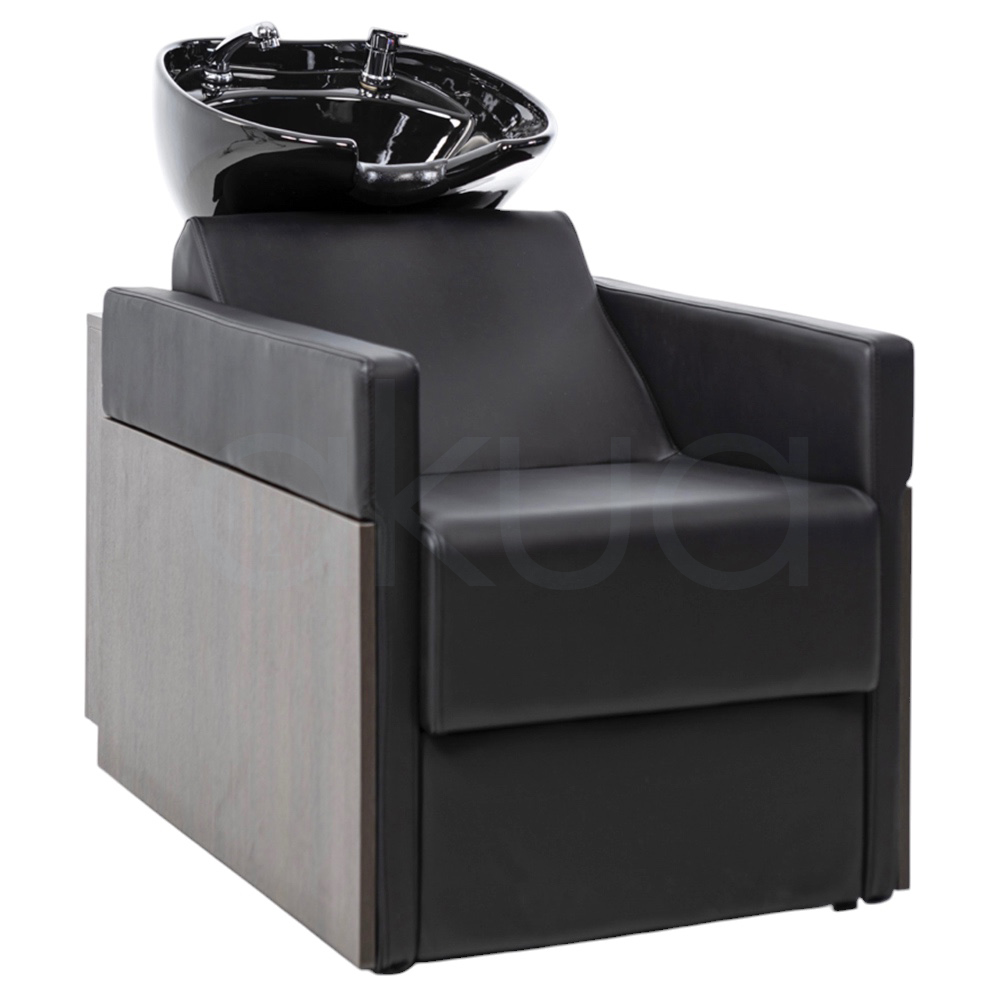 Lavacabezas Rustik negro H2oAkua. La imagen muestra un lavacabezas de peluquería moderno, compuesto por un sillón tapizado en color negro con apoyabrazos anchos y estructura lateral de aspecto madera. En la parte superior, integrado al respaldo, se encuentra una cubeta o pila de lavado de cerámica negra diseñada para lavar el cabello de los clientes.