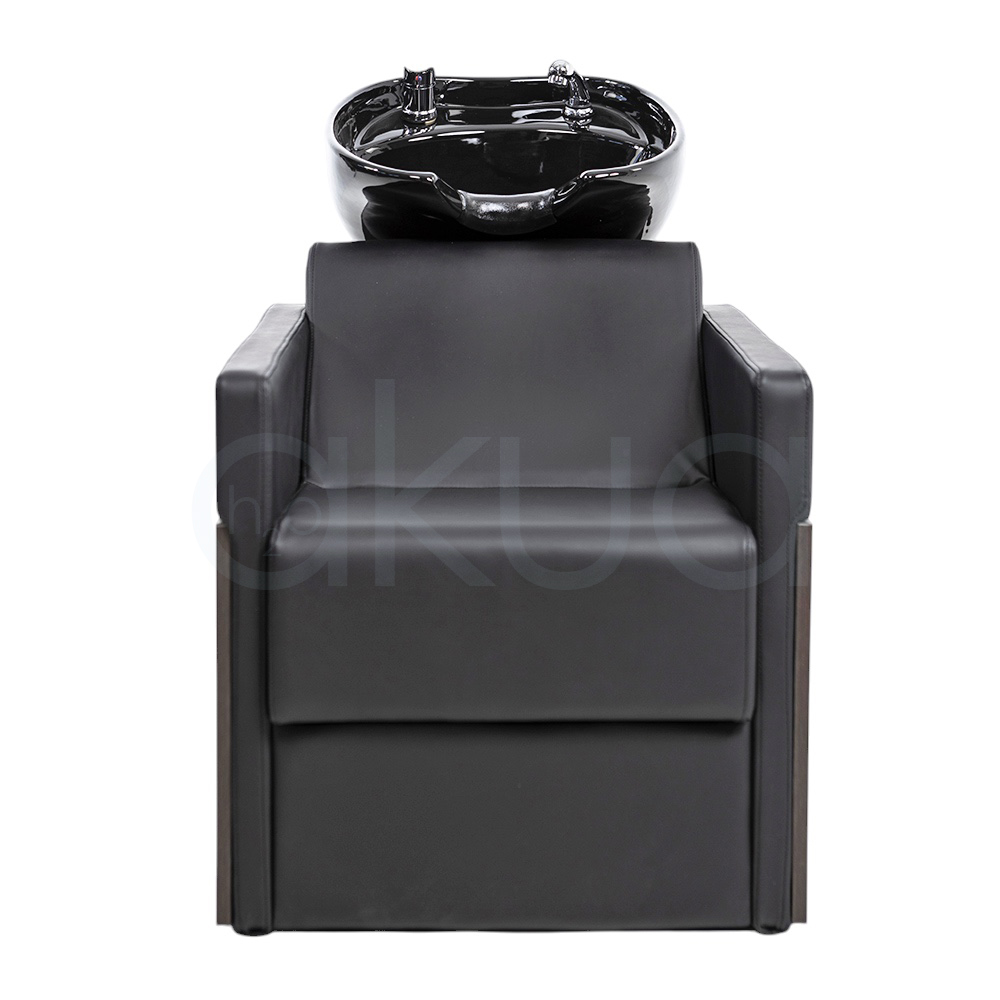 Lavacabezas Rustik negro H2oAkua. La imagen muestra un lavacabezas de peluquería moderno, compuesto por un sillón tapizado en color negro con apoyabrazos anchos y estructura lateral de aspecto madera. En la parte superior, integrado al respaldo, se encuentra una cubeta o pila de lavado de cerámica negra diseñada para lavar el cabello de los clientes.