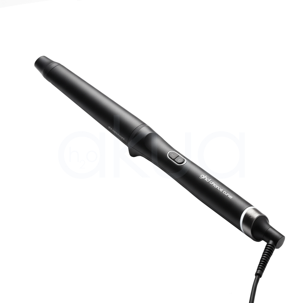Rizador ghd Chronos Curve Conical. La imagen muestra el rizador de pelo profesional ghd Chronos Curve Conical junto a su caja de presentación. Ambos elementos están sobre un fondo completamente blanco que resalta el diseño elegante y moderno del producto. El rizador es de color negro con detalles metálicos y se distingue por su forma cónica, ideal para crear ondas y rizos definidos en el cabello. La caja negra presenta el nombre del producto y el logotipo de la marca ghd en letras blancas, mostrando una estética minimalista y premium. H2o Akua
