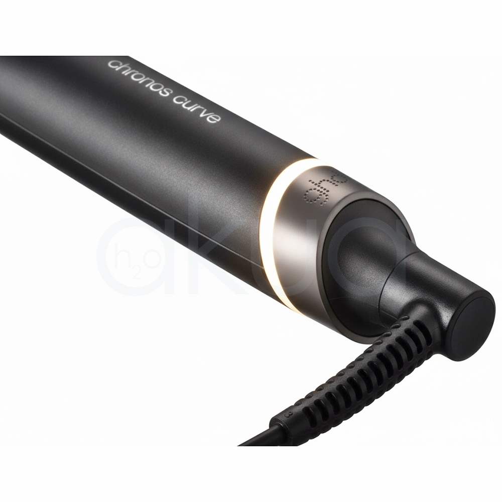Rizador ghd Chronos Curve Conical. La imagen muestra el rizador de pelo profesional ghd Chronos Curve Conical junto a su caja de presentación. Ambos elementos están sobre un fondo completamente blanco que resalta el diseño elegante y moderno del producto. El rizador es de color negro con detalles metálicos y se distingue por su forma cónica, ideal para crear ondas y rizos definidos en el cabello. La caja negra presenta el nombre del producto y el logotipo de la marca ghd en letras blancas, mostrando una estética minimalista y premium. H2o Akua