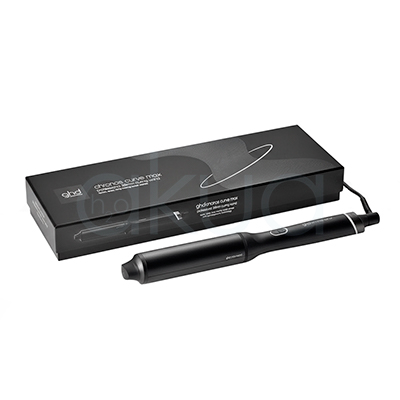Rizador ghd Chronos Curve Max. La imagen muestra el rizador de pelo profesional ghd Chronos Curve Max junto a su caja de presentación. Ambos elementos están sobre un fondo completamente blanco que resalta el diseño elegante y moderno del producto. El rizador es de color negro con detalles metálicos y se distingue por su forma cónica, ideal para crear ondas y rizos definidos en el cabello. La caja negra presenta el nombre del producto y el logotipo de la marca ghd en letras blancas, mostrando una estética minimalista y premium. H2o Akua