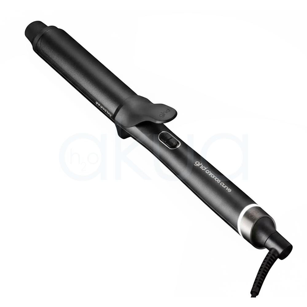Tenacilla ghd Chonos Curve Grand. La imagen muestra la tenacilla de pelo profesional ghd Chronos Curve Grand junto a su caja de presentación. Ambos elementos están sobre un fondo completamente blanco que resalta el diseño elegante y moderno del producto. La tenacilla es de color negro con detalles metálicos y se distingue por su forma cónica, ideal para crear ondas y rizos definidos en el cabello. La caja negra presenta el nombre del producto y el logotipo de la marca ghd en letras blancas, mostrando una estética minimalista y premium. H2o Akua