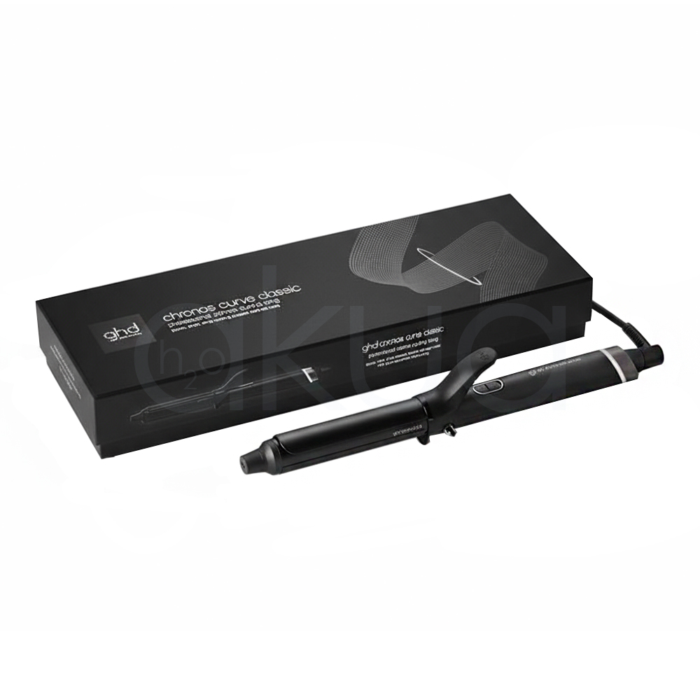Tenacilla ghd Chronos Curve Classic. La imagen muestra la tenacilla de pelo profesional ghd Chronos Curve Classic junto a su caja de presentación. Ambos elementos están sobre un fondo completamente blanco que resalta el diseño elegante y moderno del producto. La tenacilla es de color negro con detalles metálicos y se distingue por su forma cónica, ideal para crear ondas y rizos definidos en el cabello. La caja negra presenta el nombre del producto y el logotipo de la marca ghd en letras blancas, mostrando una estética minimalista y premium. H2o Akua