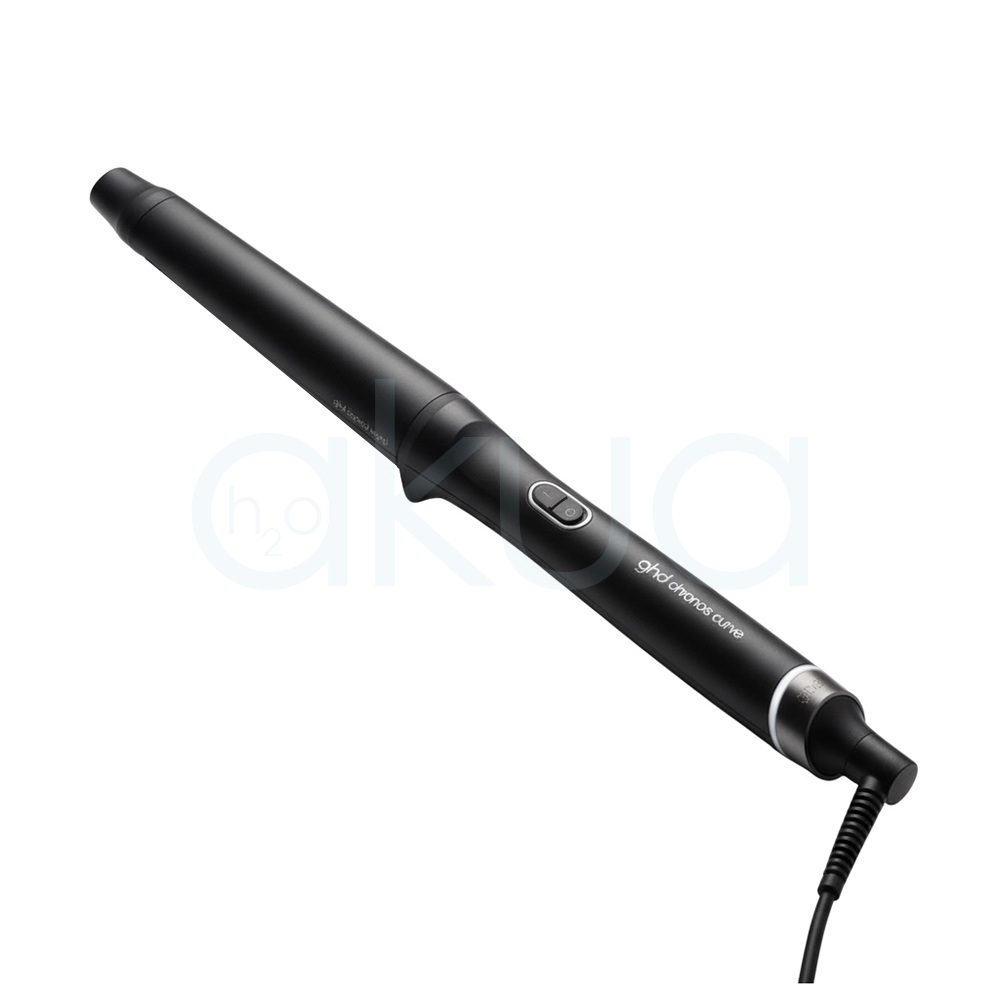Tenacilla ghd Chronos Curve Classic. La imagen muestra la tenacilla de pelo profesional ghd Chronos Curve Classic junto a su caja de presentación. Ambos elementos están sobre un fondo completamente blanco que resalta el diseño elegante y moderno del producto. La tenacilla es de color negro con detalles metálicos y se distingue por su forma cónica, ideal para crear ondas y rizos definidos en el cabello. La caja negra presenta el nombre del producto y el logotipo de la marca ghd en letras blancas, mostrando una estética minimalista y premium. H2o Akua