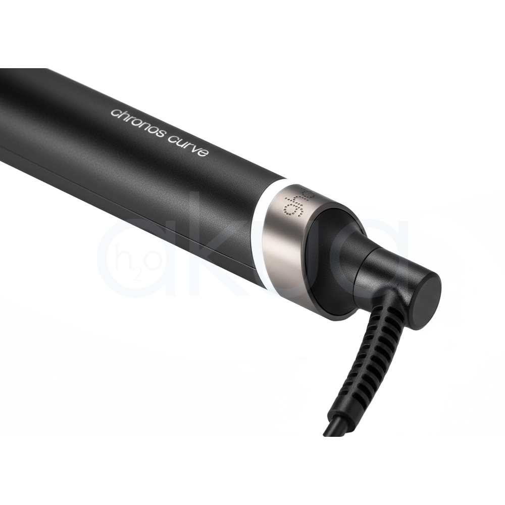 Tenacilla ghd Chronos Curve Classic. La imagen muestra la tenacilla de pelo profesional ghd Chronos Curve Classic junto a su caja de presentación. Ambos elementos están sobre un fondo completamente blanco que resalta el diseño elegante y moderno del producto. La tenacilla es de color negro con detalles metálicos y se distingue por su forma cónica, ideal para crear ondas y rizos definidos en el cabello. La caja negra presenta el nombre del producto y el logotipo de la marca ghd en letras blancas, mostrando una estética minimalista y premium. H2o Akua