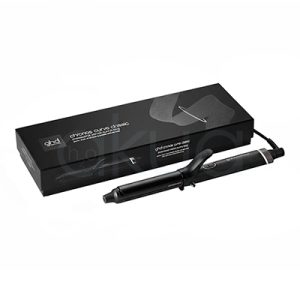 Tenacilla ghd Chronos Curve Classic. La imagen muestra la tenacilla de pelo profesional ghd Chronos Curve Classic junto a su caja de presentación. Ambos elementos están sobre un fondo completamente blanco que resalta el diseño elegante y moderno del producto. La tenacilla es de color negro con detalles metálicos y se distingue por su forma cónica, ideal para crear ondas y rizos definidos en el cabello. La caja negra presenta el nombre del producto y el logotipo de la marca ghd en letras blancas, mostrando una estética minimalista y premium. H2o Akua