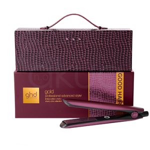 Plancha ghd Gold Cherry Chic Collection. Set de plancha de pelo ghd en edición limitada de color burdeos. La imagen muestra una caja rígida texturizada tipo estuche con asa en la parte superior, colocada sobre otra caja del mismo tono donde se lee “ghd gold professional advanced styler”, y delante aparece la plancha alisadora del mismo color, con placas negras y el logotipo de ghd en el lateral. H2o Akua