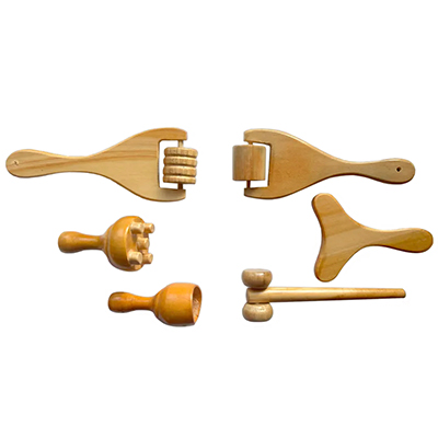 Kit mini facial 6 pieza Maderoterapia. En la imagen se ve un kit de maderoterapia corporal de seis piezas de madera clara: dos rodillos tipo “tenedor” (uno estriado y otro liso), una tabla moldeadora en forma de Y, un champiñón masajeador, una copa sueca y un rodillo de doble bola con mango largo. H2o Akua