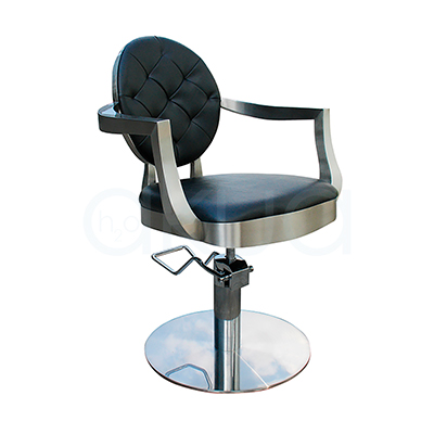 Sillon pie redondo Chic negro 06096/50/2. El sillón Chic tiene un respaldo redondo tapizado en negro con capitoné (rombos acolchados) y un asiento también negro de forma circular ligeramente ovalada. La estructura, los brazos curvos y la base redonda hidráulica son metálicas en acabado plateado/cromado, creando un contraste elegante negro‑plata. H2o Akua 