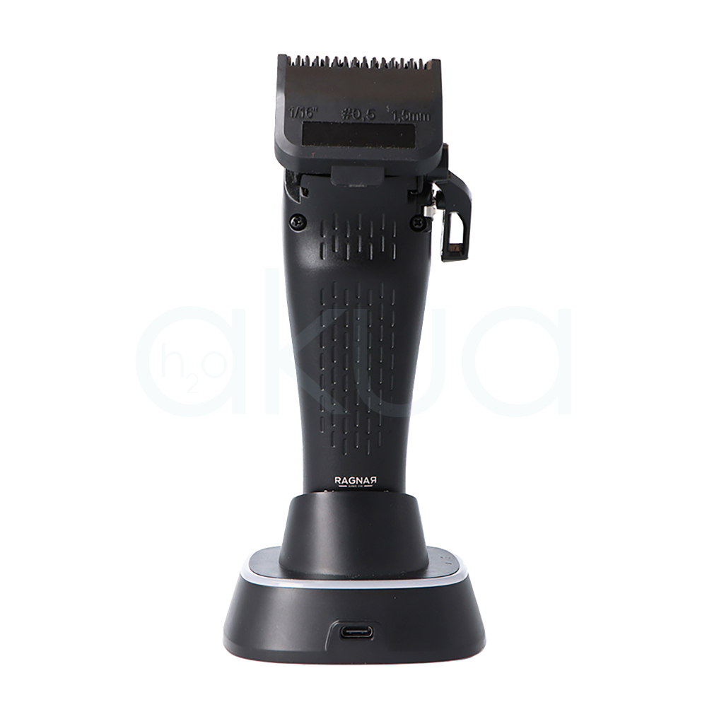 Maquina de corte X-Tech Ragnar 09179. La máquina es de color negro mate con algunos detalles en gris y transparente en la zona central donde se ve parte del mecanismo interior. La forma del cuerpo es alargada y ergonómica, ensanchándose ligeramente en la parte superior y estrechándose hacia la base para facilitar el agarre, con una cuchilla recta en la parte superior y un soporte de carga rectangular redondeado en la parte inferior. H20 Akua