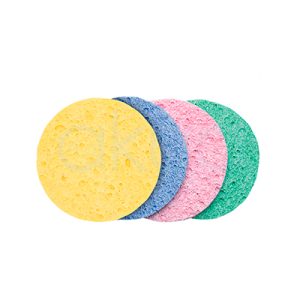 Esponja desmaquillar poros 90mm paquete 100 unid. La imagen muestra cuatro esponjas redondas de desmaquillado para limpiar poros, apiladas en perspectiva sobre fondo blanco. Son discos circulares uniformes de esponja hidrófila (celulosa), textura porosa absorbente; colores pastel: amarillo, azul, rosa y verde. Tamaño aprox. 6-8 cm diámetro, grosor 0.5 cm, ideales para rostro sin irritar pieles sensibles