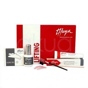 Kit Lifting completo de pestañas Thuya. Presentado sobre un fondo completamente blanco. En el centro se ve una caja grande de color rojo con el logo “Thuya Professional Line” en blanco y la palabra “Lifting” en vertical. Delante de la caja aparecen varios productos del kit: Un estuche gris y blanco etiquetado “Silicone Pads”, Un bote plateado y blanco de adhesivo o cola de lifting, Dos cajas alargadas con sus respectivos tubos, uno de Gel Permanente y otro de Neutralizante o crema neutralizante, Un pequeño cepillo negro con cabezal rojo y un palito de naranjo de madera. La composición está ordenada y simétrica, con iluminación suave que resalta los colores rojo, blanco y gris, dándole aspecto de fotografía de catálogo para peluquería y estética. H2o Akua
