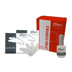 Kit Lifting essentials de pestañas Thuya. La imagen muestra el kit Thuya Lifting Essentials para lifting profesional de pestañas, con una caja roja principal etiquetada "Thuya Lifting Essentials" como elemento central. A la izquierda, dos paquetes de pads de silicona gris ("Silicone Pads") para elevar las pestañas; al frente, un frasco gris de cola adhesiva Thuya; y a la derecha, una caja pequeña blanca con el logo Thuya. H2o Akua