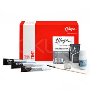 Kit tinte especial pestañas Thuya. kit profesional de estética para pestañas de la marca Thuya. En el fondo hay una caja rectangular roja y blanca con el texto “Professional Line”, “Tint” y “Pestañas / Eyelashes”. Delante de la caja aparecen varios productos: tres tubitos negros tipo crema o tinte, un sobre plateado de “Fayel Protector”, un tubo gris, un pequeño frasco blanco, un vasito de cristal transparente y un pincel fino de mango claro. Todo está dispuesto sobre una superficie blanca y de ser un set completo para tinte o permanente de pestañas. H2o Akua