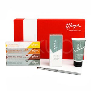 Kit tinte de cejas Thuya. En primer plano hay cuatro tubos de tinte en tonos distintos (amarillo, naranja, rojo y azul, probablemente para mezclar colores finales), una caja gris con “Substrato Especial”, una caja blanca con “Crema Oxidante”, un pincel de mango negro y una brocha. H2o Akua