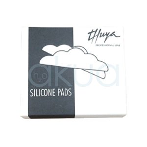 Moldes Pads de silicona lifting Thuya. Es una caja rectangular negra y blanca con diseño elegante. Lado izquierdo: Fondo negro con logo Thuya en plateado y "Professional Line" debajo. Lado derecho: Fondo blanco con ilustración minimalista de nubes blancas estilizadas y el logo "h2oku" (marca de pads de silicona). Texto "SILICONE PADS" en mayúsculas azules. H2o Akua ​