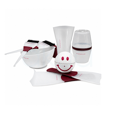Kit tecnico premium tintura H2oAkua. El conjunto incluye un bol mezclador blanco con dos brochas aplicadoras apoyadas encima, ambas con mango en color burdeos y cerdas negras. En la parte trasera aparece un vaso medidor translúcido y un recipiente dosificador con tapa semitransparente. En el centro destaca una pequeña esfera blanca decorada con una cara sonriente en color rosa oscuro. En la parte inferior se observan dos paletas protectoras translúcidas con detalles en burdeos. Todos los accesorios mantienen un diseño moderno y minimalista en tonos blancos y burdeos, orientado al uso profesional en peluquería y tintura capilar.”