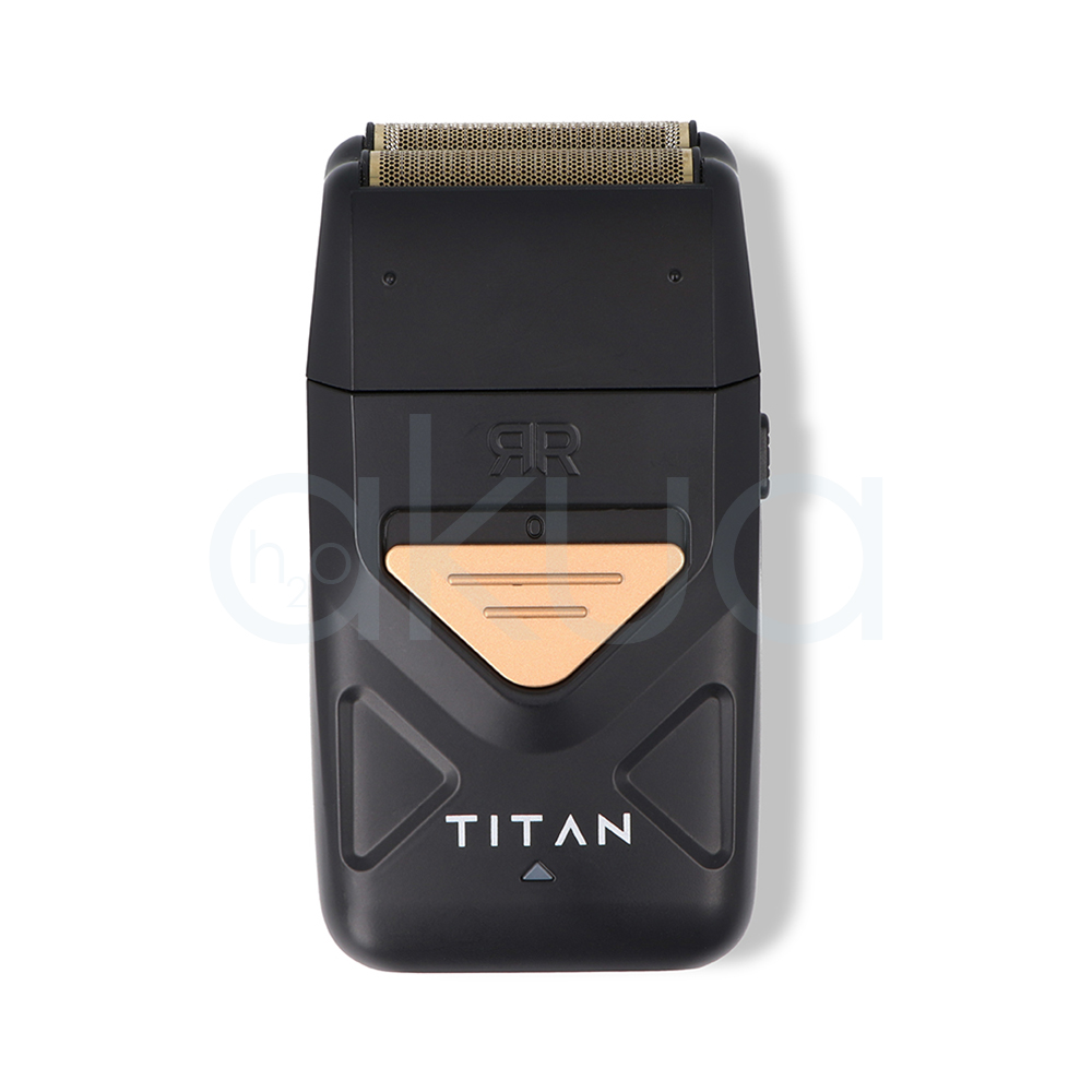 Afeitadora Titan Ragnar. Afeitadora profesional de acabado tipo foil en color negro mate con detalles metálicos dorados. En la parte superior incorpora un doble cabezal de láminas metálicas diseñado para proporcionar un afeitado preciso y apurado. El cuerpo presenta un diseño compacto y ergonómico con un panel triangular dorado en la zona frontal y la inscripción "TITAN" en letras blancas. La afeitadora está colocada sobre una base de carga negra con el logotipo "Ragnar Barber Line" visible en la parte frontal. La imagen se presenta sobre un fondo claro, resaltando el aspecto moderno, elegante y profesional de la herramienta, especialmente orientada a barberías y acabados de precisión. H2o Akua