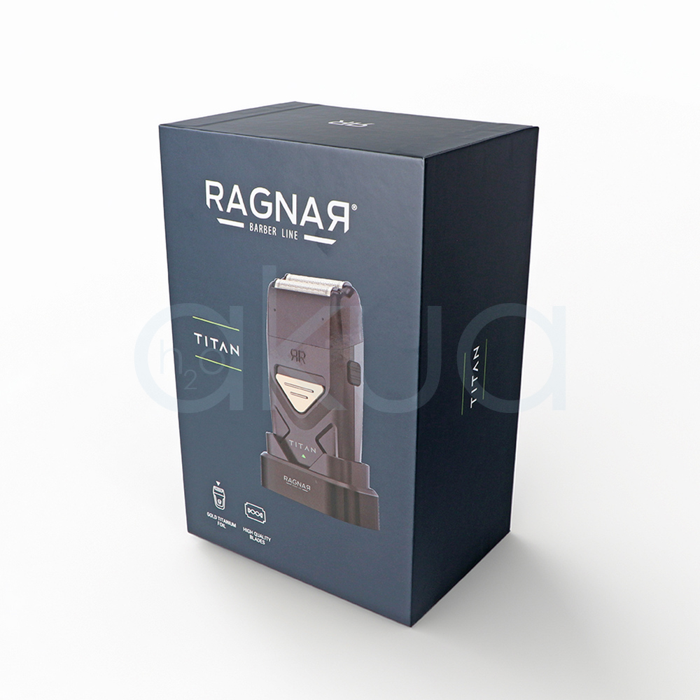 Afeitadora Titan Ragnar. Afeitadora profesional de acabado tipo foil en color negro mate con detalles metálicos dorados. En la parte superior incorpora un doble cabezal de láminas metálicas diseñado para proporcionar un afeitado preciso y apurado. El cuerpo presenta un diseño compacto y ergonómico con un panel triangular dorado en la zona frontal y la inscripción "TITAN" en letras blancas. La afeitadora está colocada sobre una base de carga negra con el logotipo "Ragnar Barber Line" visible en la parte frontal. La imagen se presenta sobre un fondo claro, resaltando el aspecto moderno, elegante y profesional de la herramienta, especialmente orientada a barberías y acabados de precisión. H2o Akua