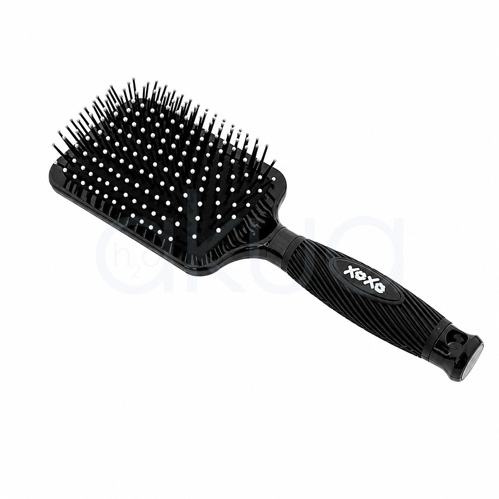 Cepillo desenredante The Voice Giubra. Cepillo paleta rectangular para cabello en color negro brillante, fotografiado sobre un fondo blanco. La base incorpora numerosas púas flexibles negras con puntas redondeadas de color rosa distribuidas uniformemente para desenredar el cabello con suavidad. El mango ergonómico, también negro, presenta un diseño estriado que mejora el agarre y una placa decorativa con el logotipo “xoxo” en color blanco. El cepillo aparece inclinado en diagonal, mostrando claramente su superficie de trabajo y su diseño moderno, ideal para el cuidado diario y el desenredado de todo tipo de cabellos.H2o Akua