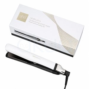 Plancha ghd Platinum+ blanca. Plancha de pelo GHD Platinum+ en color blanco con detalles negros y metálicos, colocada sobre un fondo blanco junto a su caja original a juego. La plancha aparece cerrada en posición diagonal, destacando su diseño elegante y minimalista. La caja blanca incorpora detalles dorados y la imagen del producto en uno de sus laterales, transmitiendo una estética moderna y profesional orientada al cuidado y peinado del cabello. H2o Akua