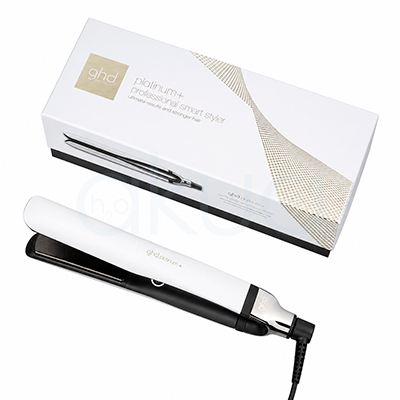 Plancha ghd Platinum+ blanca. Plancha de pelo GHD Platinum+ en color blanco con detalles negros y metálicos, colocada sobre un fondo blanco junto a su caja original a juego. La plancha aparece cerrada en posición diagonal, destacando su diseño elegante y minimalista. La caja blanca incorpora detalles dorados y la imagen del producto en uno de sus laterales, transmitiendo una estética moderna y profesional orientada al cuidado y peinado del cabello. H2o Akua