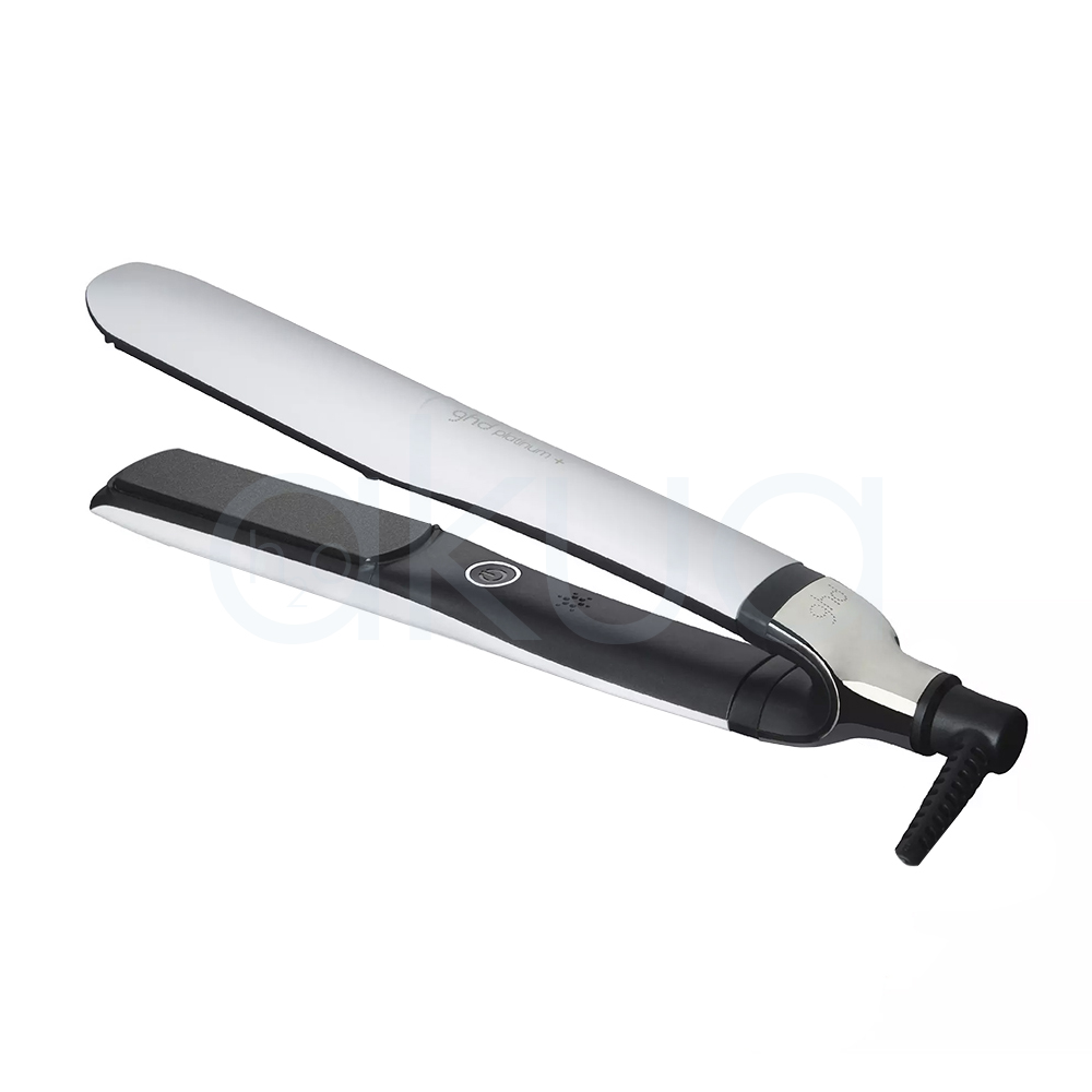 Plancha ghd Platinum+ blanca. Plancha de pelo GHD Platinum+ en color blanco con detalles negros y metálicos, colocada sobre un fondo blanco junto a su caja original a juego. La plancha aparece cerrada en posición diagonal, destacando su diseño elegante y minimalista. La caja blanca incorpora detalles dorados y la imagen del producto en uno de sus laterales, transmitiendo una estética moderna y profesional orientada al cuidado y peinado del cabello. H2o Akua
