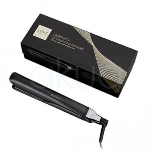 Plancha ghd Platinum+ negra. Plancha de pelo profesional GHD Platinum+ en color negro, presentada junto a su caja original negra con detalles dorados. La plancha aparece cerrada y colocada en diagonal sobre fondo blanco, mostrando un diseño elegante y minimalista. El cable giratorio y los acabados metálicos resaltan su aspecto premium, mientras que el embalaje refleja la imagen sofisticada de la marca. H2o Akua